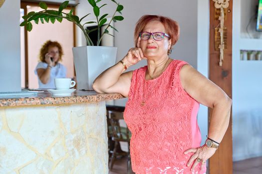 Portrait of an elderly smiling woman of 70s years old. Positive senior woman with glasses looking at camera in cafe. Pensioner age, grandmother, beauty health lifestyle, people of retirement age