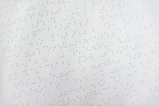 A fragment of text in Louis Braille printed on a standard sheet of paper using special printing equipment.