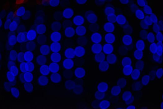 Group of blue holiday lights on dark background of night.