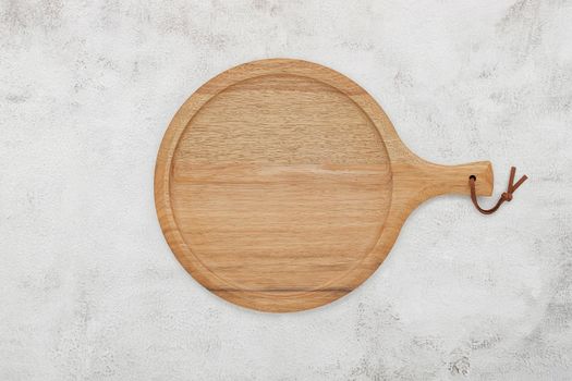 Empty wooden pizza platter set up on white concrete. Pizza tray on white concrete background flat lay and copy space.
