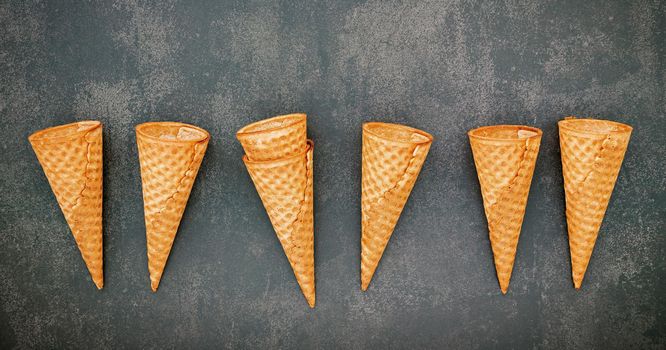 Flat lay ice cream cones collection on dark stone background . Blank crispy ice cream cone with copy space for sweets menu design.