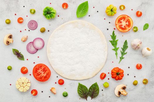 The ingredients for homemade pizza set up on white concrete background  flat lay and copy space.