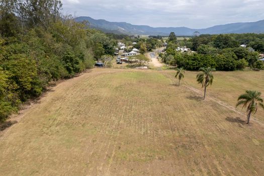 Aerial landscape over a grassy park towards the township of Finch Hatton, Queensland, Australia