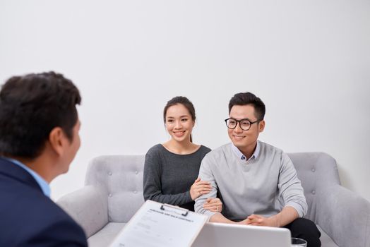 Happy young couple hold each other hands listening to female agent, planning wedding, consulting investment advisor, hearing good news, casual marriage registration, buying real estate