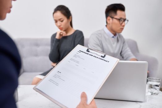 Young angry couple of cheated investors holding papers arguing with male real estate agent, defrauded property purchasers protecting their rights, too high interest rate of banking loan or mortgage