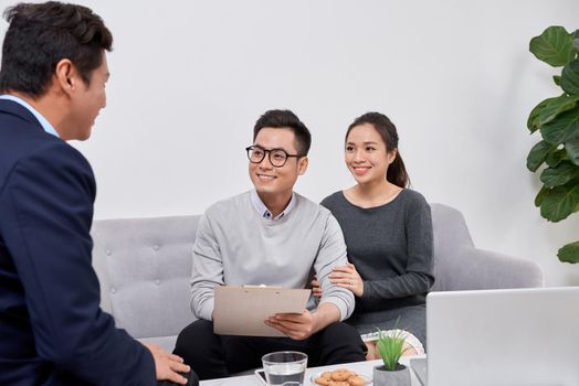 Sales Consultant showing new investment plans to young asian couple