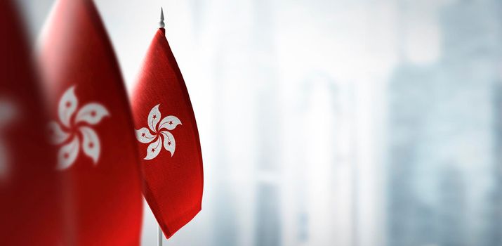 Small flags of Hong Kong on a blurry background of the city.