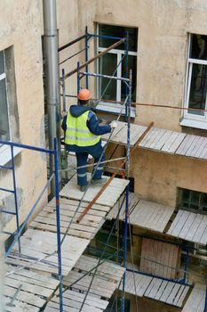 Saint Petersburg, Russia - April 24, 2021: Workers erect scaffolding to repair the facade of a building