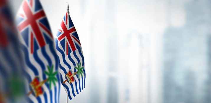 Small flags of British Indian Ocean Territory on a blurry background of the city.