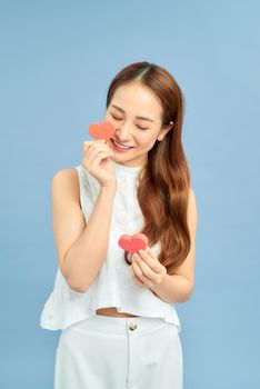 Lifestyle Concept: Attractive woman with beaming smile having two small red hearts in hands