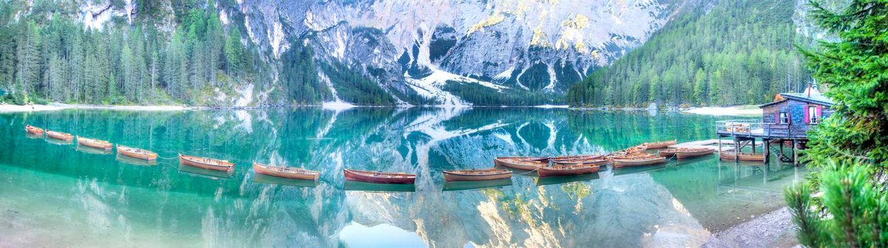 Panoramic shot of the characteristic boats of Lake Braies in the mountain range of the Dolomites Italy