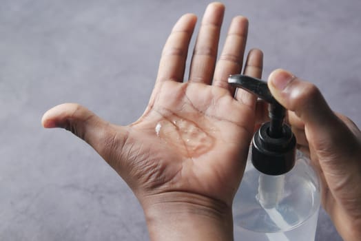 close up of young man hand using sanitizer gel for preventing virus.