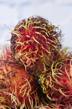 stack of rambutan in a chopping board on table .