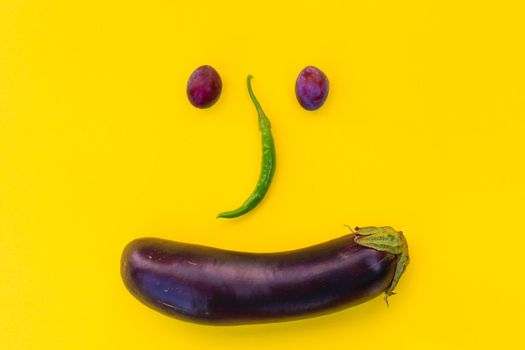 Autumn vegetables and fruits on a yellow background in the form of a muzzle. Minimalistic template, flat lay.