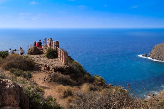 Cabo de Gata, Almeria, Spain- September 3, 2021: People enjoying the beautiful seascape from the Amatistas viewpoint in Cabo de Gata-Nijar natural park on a sunny day of summer.