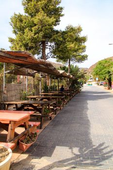 Rodalquilar, Almeria, Spain- September 8, 2021: Empty Bar terrace with wooden tables in Rodalquilar village on a sunny day of Summer.