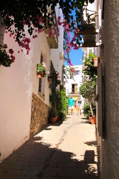 Mojacar, Almeria, Spain- September 8, 2021: Narrow streets with Whitewashed houses in Mojacar village on a sunny day of summer.