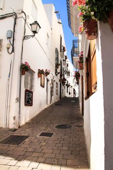 Mojacar, Almeria, Spain- September 8, 2021: Narrow streets with Whitewashed houses in Mojacar village on a sunny day of summer.