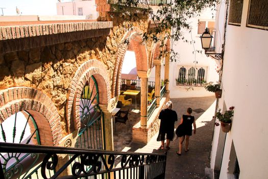 Mojacar, Almeria, Spain- September 8, 2021: Narrow streets with Whitewashed houses in Mojacar village on a sunny day of summer.