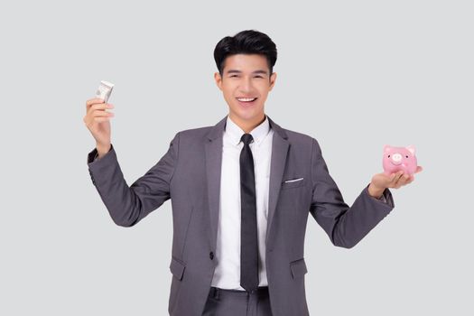 Young asian businessman in suit deposit money dollar with piggy bank isolated on white background, business man saving with planning budget and finance for success investment and financial.