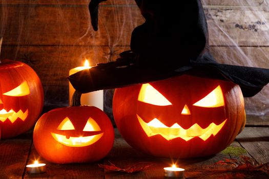 Still life of Halloween pumpkin lanterns pumpkins and hat decoration in candle light