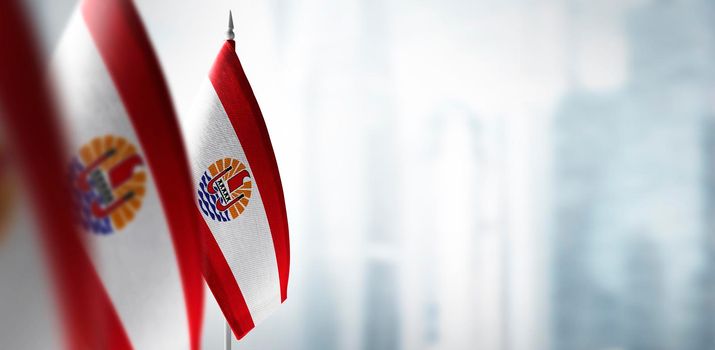 Small flags of French Polynesia on a blurry background of the city.