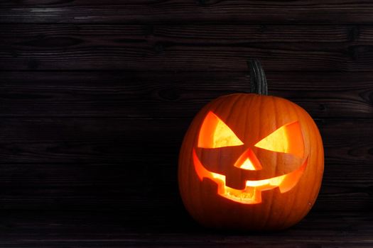 Jack o lantern Halloween pumpkin face on wooden background