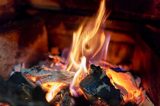 Burning black coals and fire bred in the fireplace. Close up