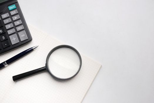 open book and magnifying glass on table