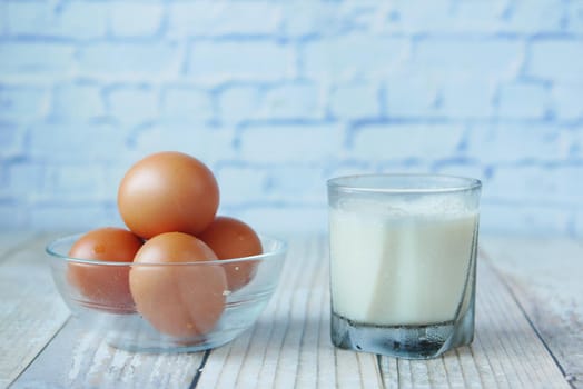 eggs in a bow and a glass of milk on table ,