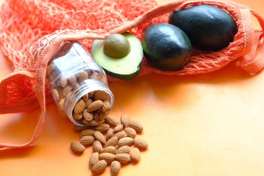 close up of slice of avocado and almond nut on chopping board.,