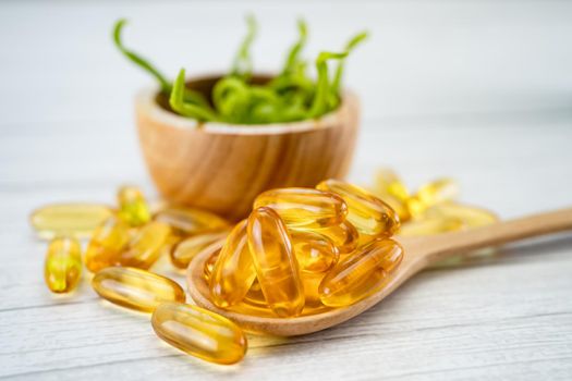 Vitamin Fish oil capsule on wooden spoon for good health.