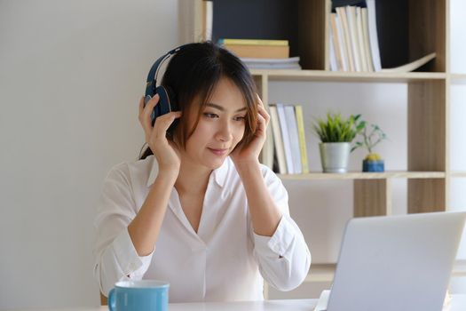 Young undergraduate student studying online class by laptop computer