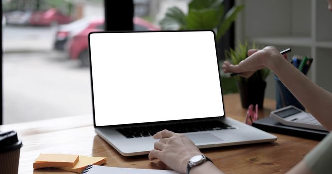 Businesswoman using laptop blank screen while working with calculator for financial.