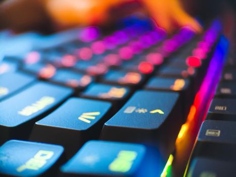 Gamer keyboard with neon backlight macro defocused close up. Online games and virtual reality concept background. High quality photo