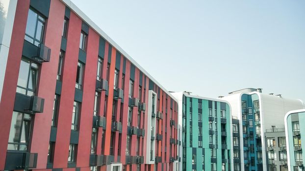 Fragment of new residential complex with buildings exterior, luxury house and home complex on blue sky background. Modern neighborhood concept.