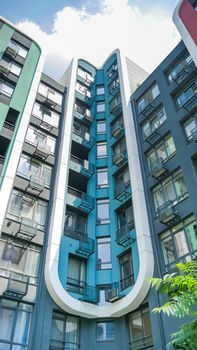 Fragment of new residential complex with buildings exterior, luxury house and home complex on blue sky background. Modern neighborhood concept.