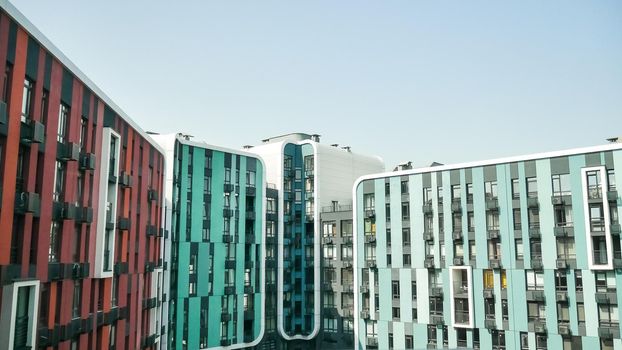 Fragment of new residential complex with buildings exterior, luxury house and home complex on blue sky background. Modern neighborhood concept.