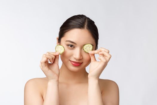 Natural homemade fresh cucumber facial eye pads facial masks. Asian woman holding cucumber pads and smile relax with natural homemade.