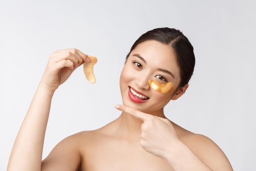 Asian beauty teenager woman care her skin with gold eye masks patches under eyes.