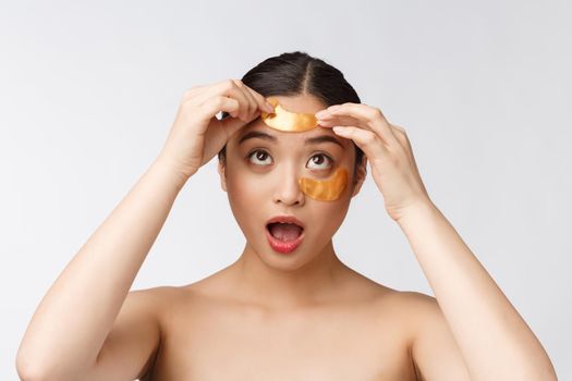 Asian beauty teenager woman care her skin with gold eye masks patches under eyes.