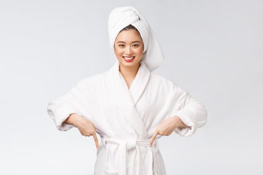 Beauty portrait of young woman showing and pointing finger to empty copy space, asian beauty in bathrobe