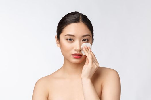 skin care woman removing face makeup with cotton swab pad - skin care concept. Facial closeup of beautiful mixed race model with perfect skin