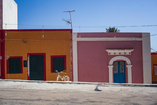 View of a typical street of Linosa with colorful house on the background