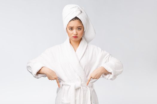 Young beautiful woman wearing shower towel after bath over isolated white background pointing with finger