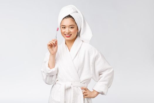 Asian happy woman with toothbrush in bathrobe morning mood.