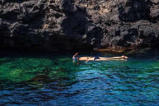 Woman Snorkeling in the blue water of Linosa sea, Linosa
