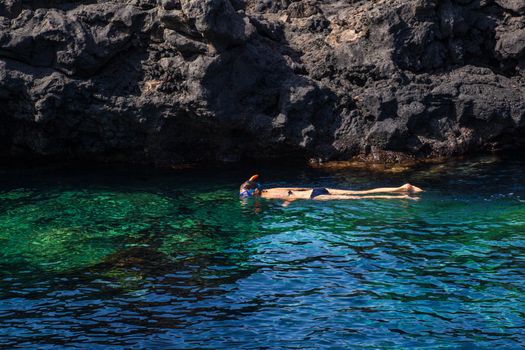 Woman Snorkeling in the blue water of Linosa sea, Linosa