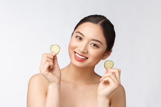 Natural homemade fresh cucumber facial eye pads facial masks. Asian woman holding cucumber pads and smile relax with natural homemade.