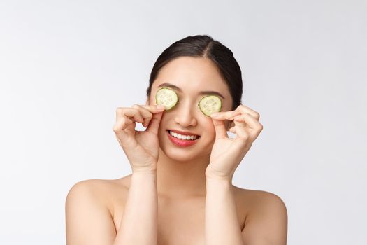 Natural homemade fresh cucumber facial eye pads facial masks. Asian woman holding cucumber pads and smile relax with natural homemade.